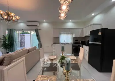 Modern open-plan living room and kitchen with elegant dining setup and stylish lighting.