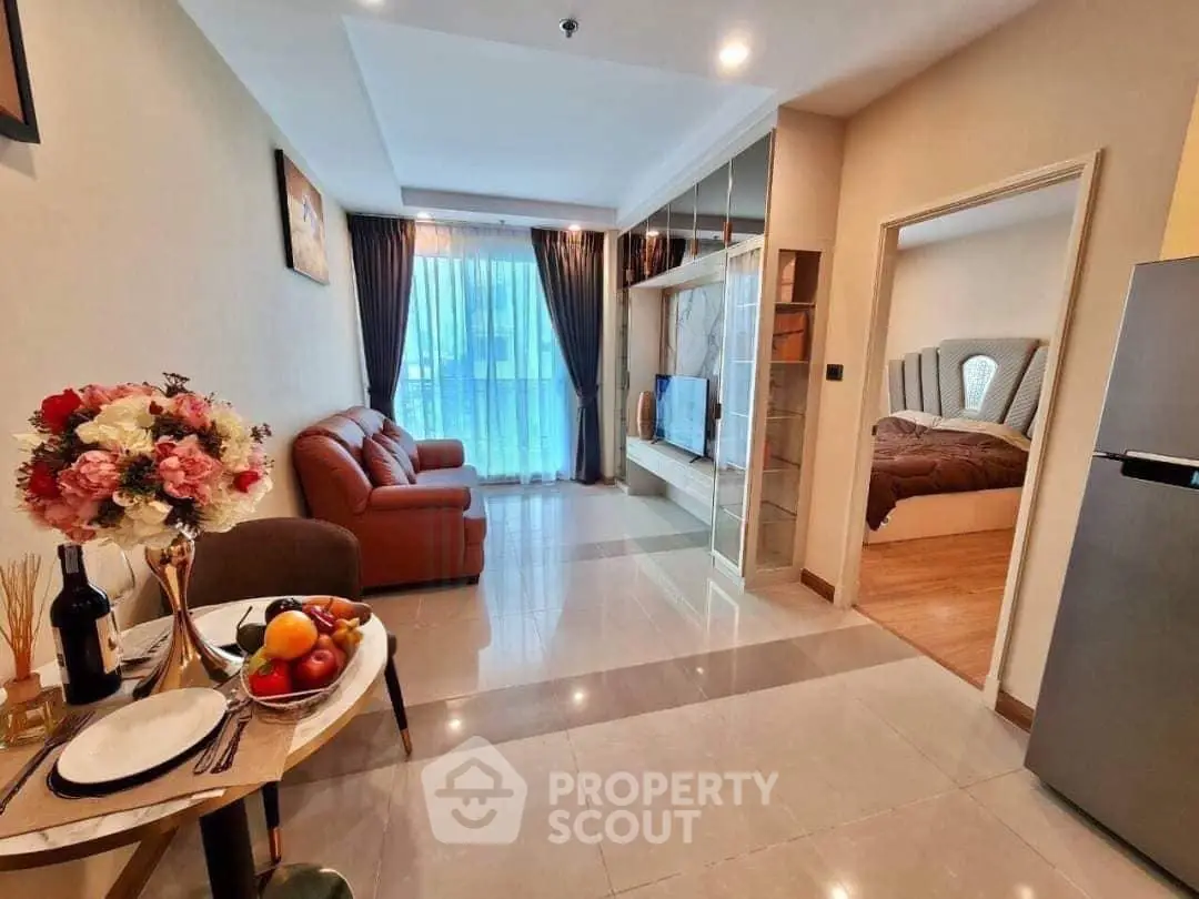 Modern open-plan living room with cozy bedroom view, elegant decor, and abundant natural light.