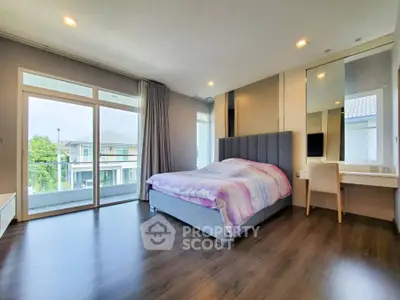 Spacious bedroom with balcony and modern decor in a bright home