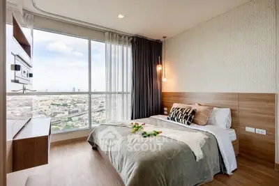 Modern bedroom with large window offering stunning city view, stylish decor, and cozy ambiance.