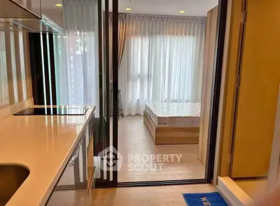 Modern studio apartment with open layout and large windows for natural light.
