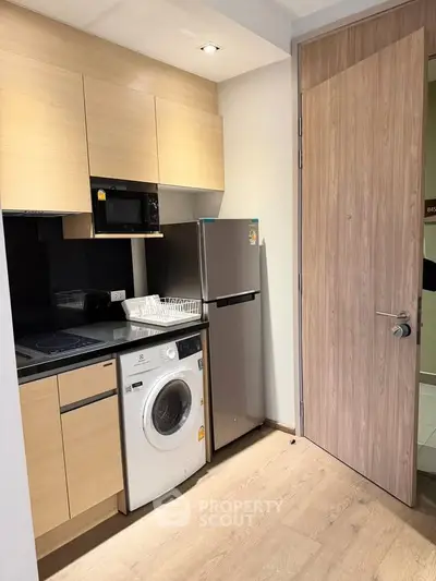 Modern compact kitchen with integrated appliances and sleek wooden cabinetry