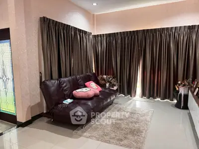 Cozy living room with dark curtains and plush sofa, perfect for relaxation.