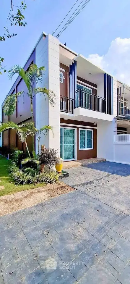 Modern two-story house with balcony and landscaped garden