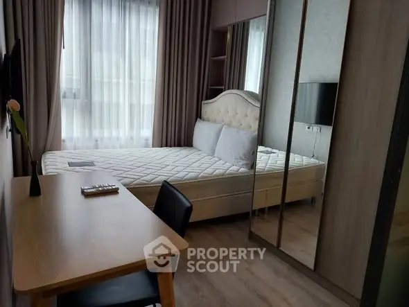 Modern bedroom with elegant decor, featuring a comfortable bed, large window, and stylish desk area.