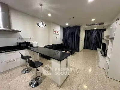 Modern open-layout kitchen and living room with sleek design and stylish furnishings.