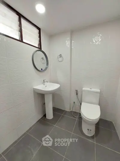 Modern bathroom with sleek white fixtures and geometric tile design.