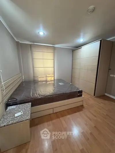 Spacious bedroom with wooden flooring and large wardrobe