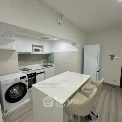 Modern kitchen with sleek appliances and breakfast bar in a stylish apartment.