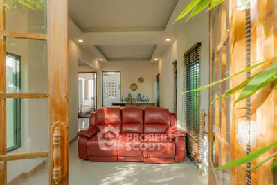 Spacious living room with red leather sofa and natural light
