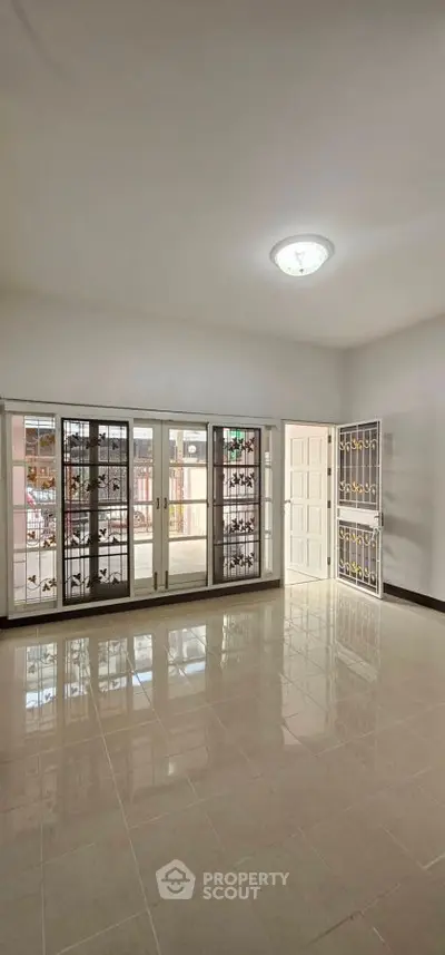 Spacious empty room with large windows and glossy tiled floor, perfect for customization.