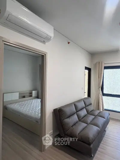 Modern apartment interior with cozy sofa and bedroom view