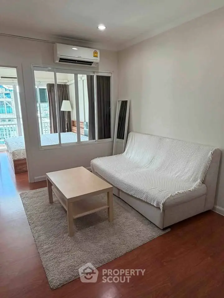 Cozy living room with modern decor and natural light, featuring a comfortable sofa and stylish coffee table.