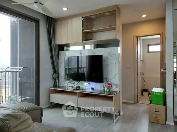 Modern living room with TV, balcony view, and stylish decor