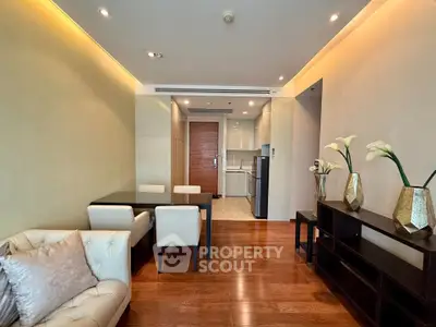 Modern living room with elegant dining area and open kitchen layout, featuring stylish decor and wooden flooring.