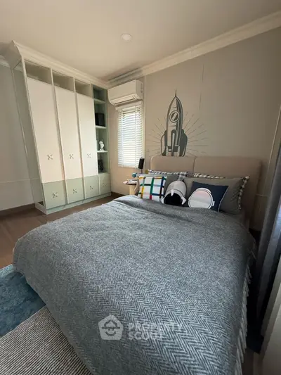 Charming bedroom with modern decor and built-in storage, perfect for cozy living.