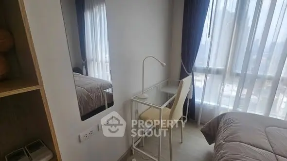 Cozy bedroom with study desk and large window offering natural light