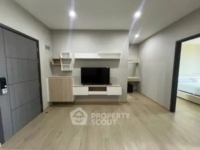 Modern living room with sleek TV unit and wooden flooring in a stylish apartment.