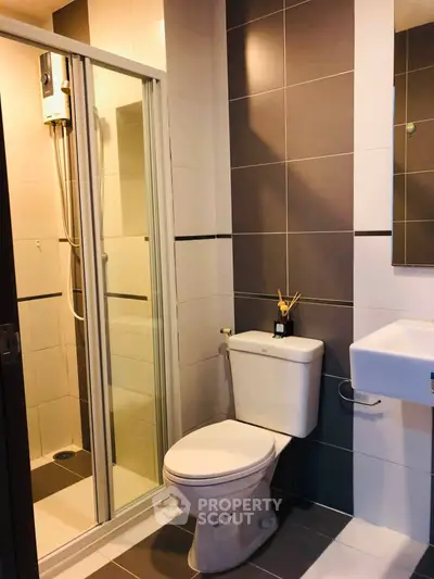 Modern bathroom with sleek design featuring a shower enclosure and stylish tiles.