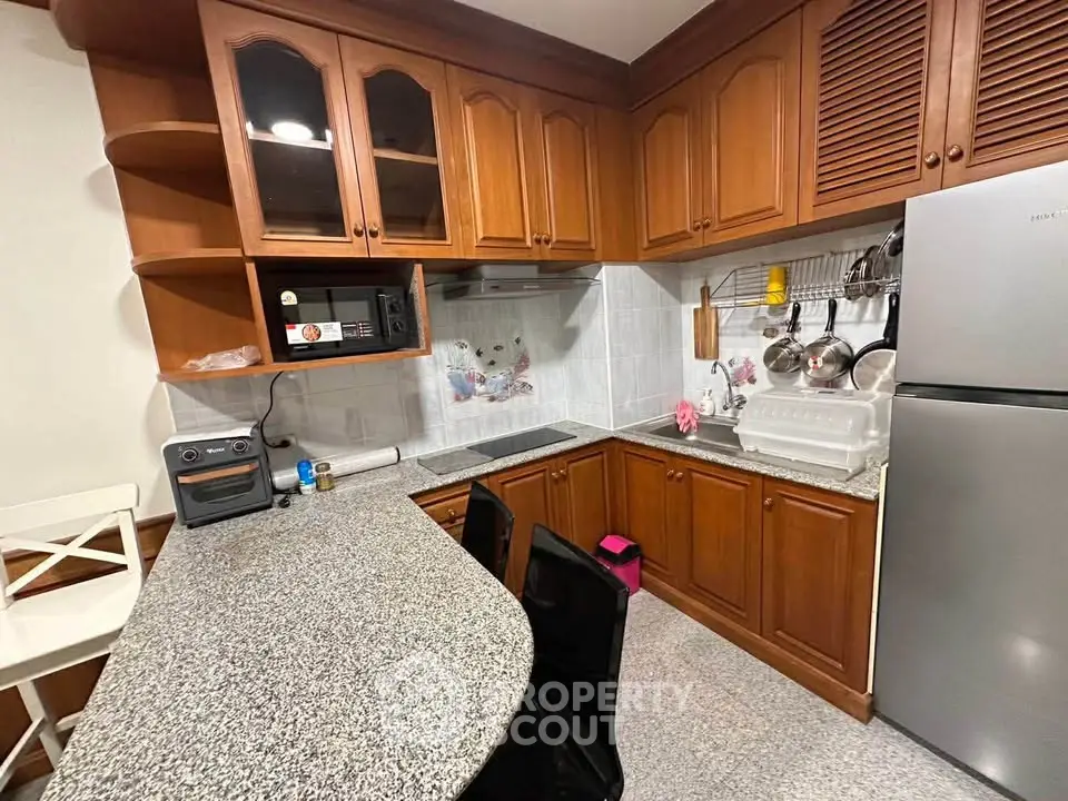 Charming kitchen with wooden cabinets and modern appliances, featuring a cozy breakfast bar and ample storage space.