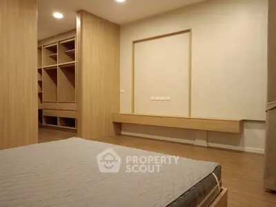 Spacious modern bedroom with built-in wooden wardrobe and minimalist design.