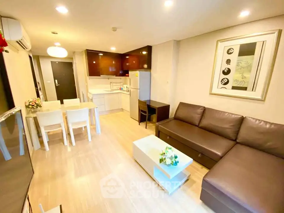 Modern open-plan living room with stylish furniture and kitchen in a cozy apartment.