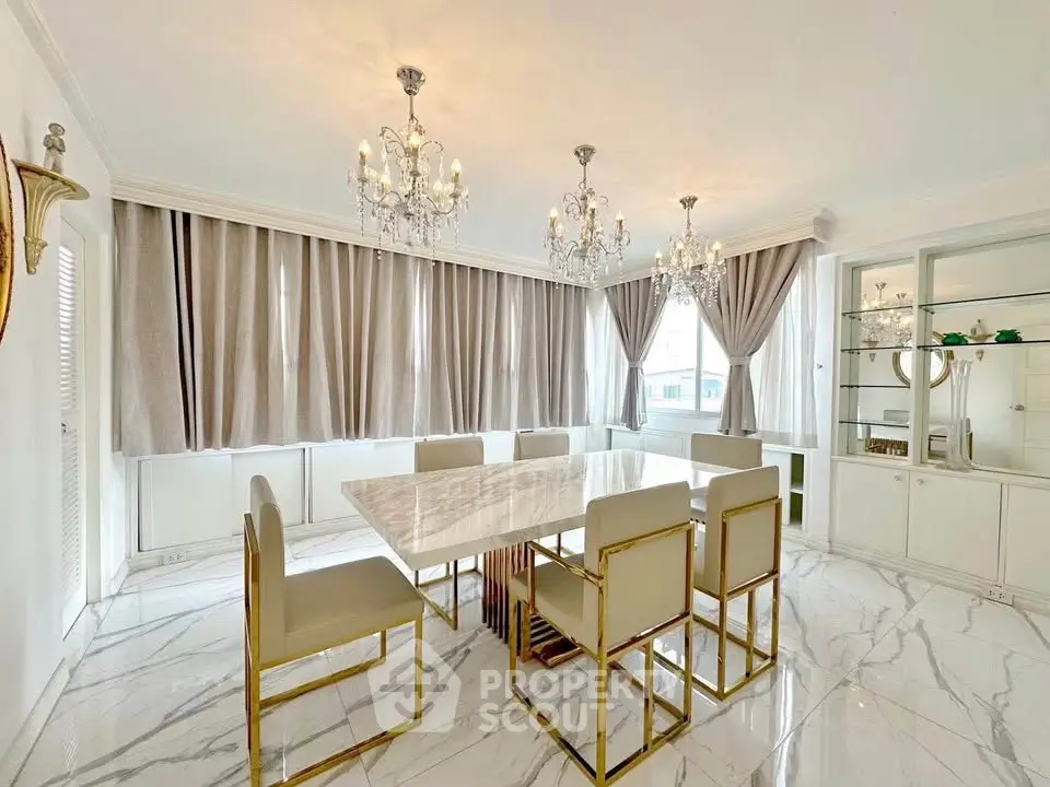 Luxurious dining room with marble flooring and elegant chandeliers in a modern apartment.