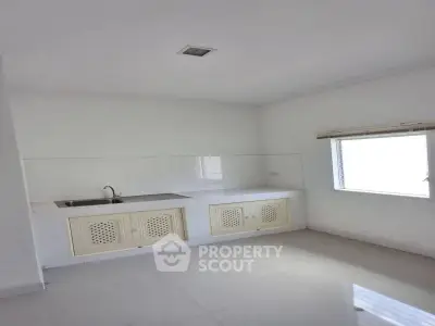 Minimalist kitchen with white cabinetry and natural light