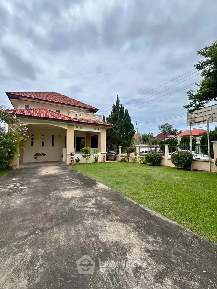 Charming two-story house with red roof and spacious front yard in a serene neighborhood.