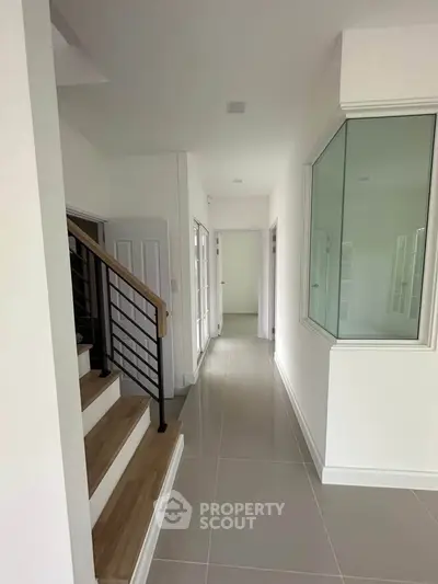 Modern hallway with sleek staircase and glass partition in a contemporary home