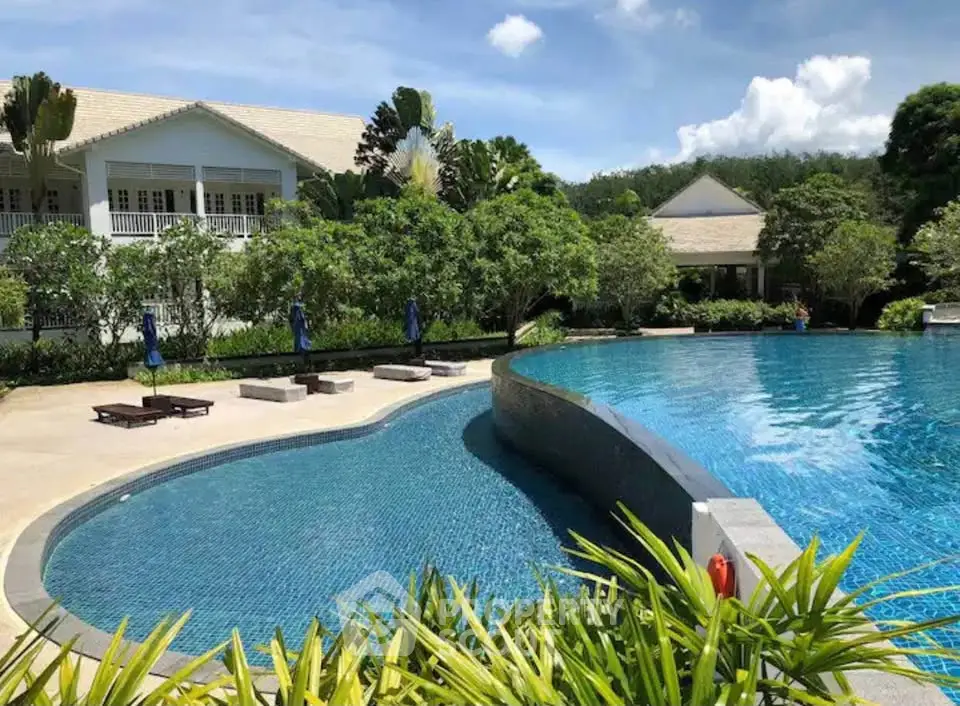 Luxurious outdoor pool area with lush greenery and elegant architecture, perfect for relaxation and leisure.