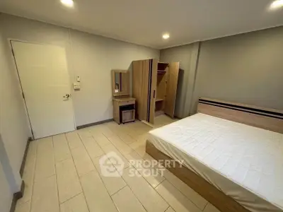 Spacious bedroom with modern furniture and ample natural light, perfect for relaxation and comfort.