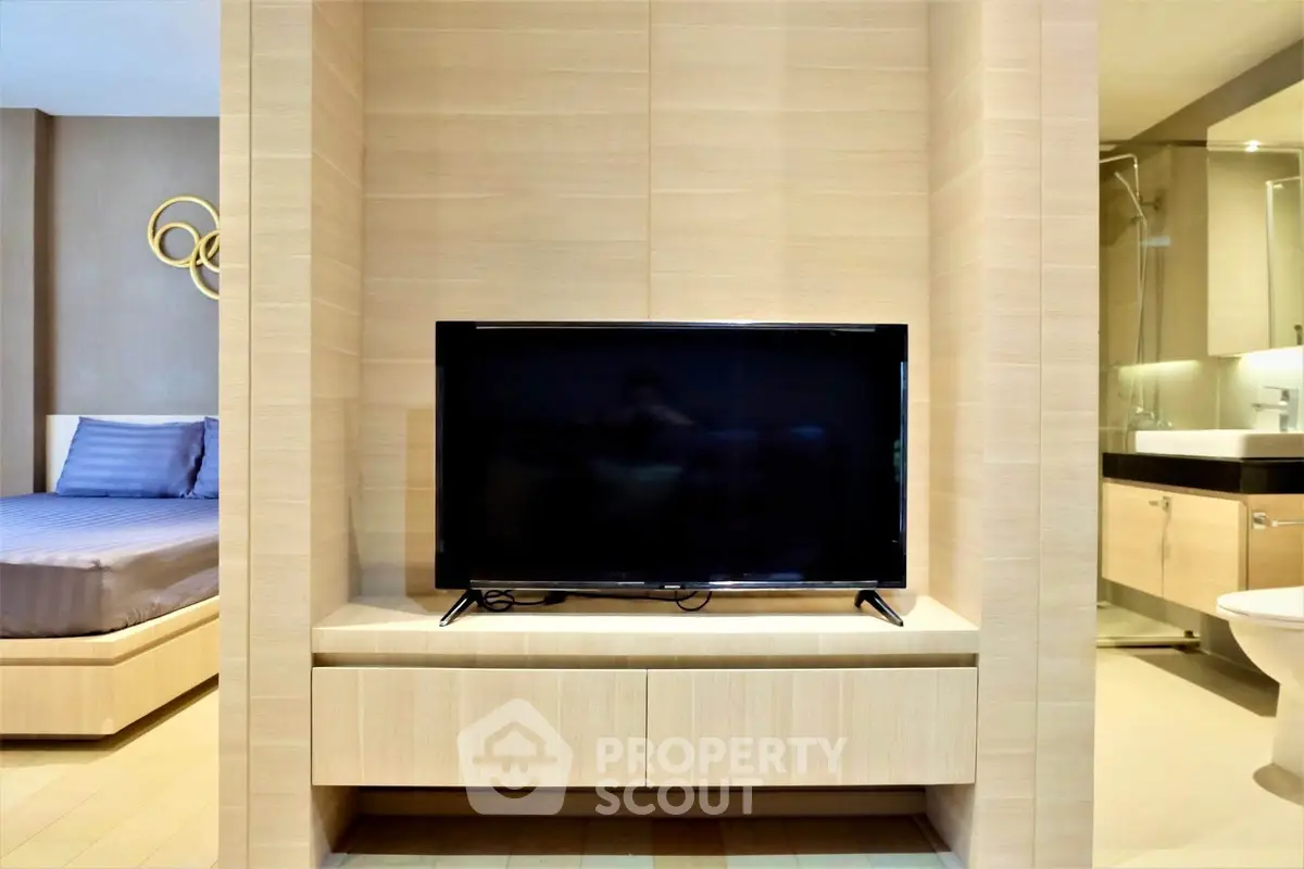 Modern bedroom with TV and ensuite bathroom in luxury apartment