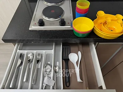 Modern kitchen with electric stove and organized cutlery drawer