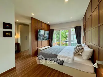 Modern bedroom with wooden paneling and large window overlooking greenery