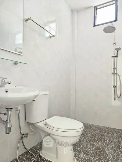 Modern bathroom with sleek fixtures and minimalist design, featuring a shower and toilet.