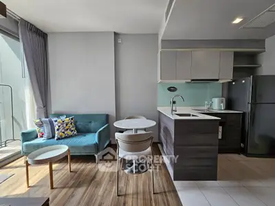 Modern open-layout living room and kitchen with stylish furniture and natural light.