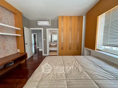 Spacious bedroom with modern decor and ensuite bathroom in a luxurious apartment.