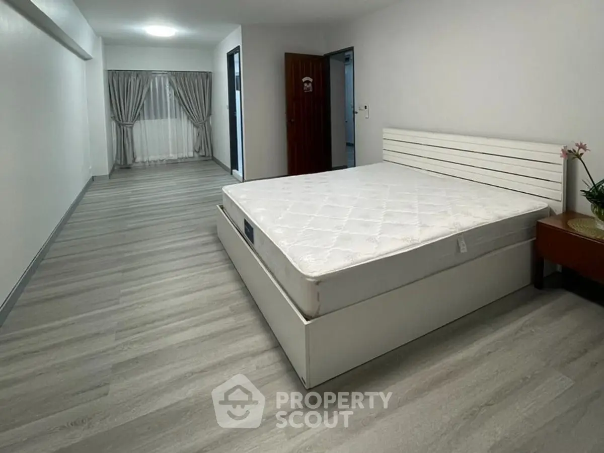 Spacious bedroom with modern flooring and natural light