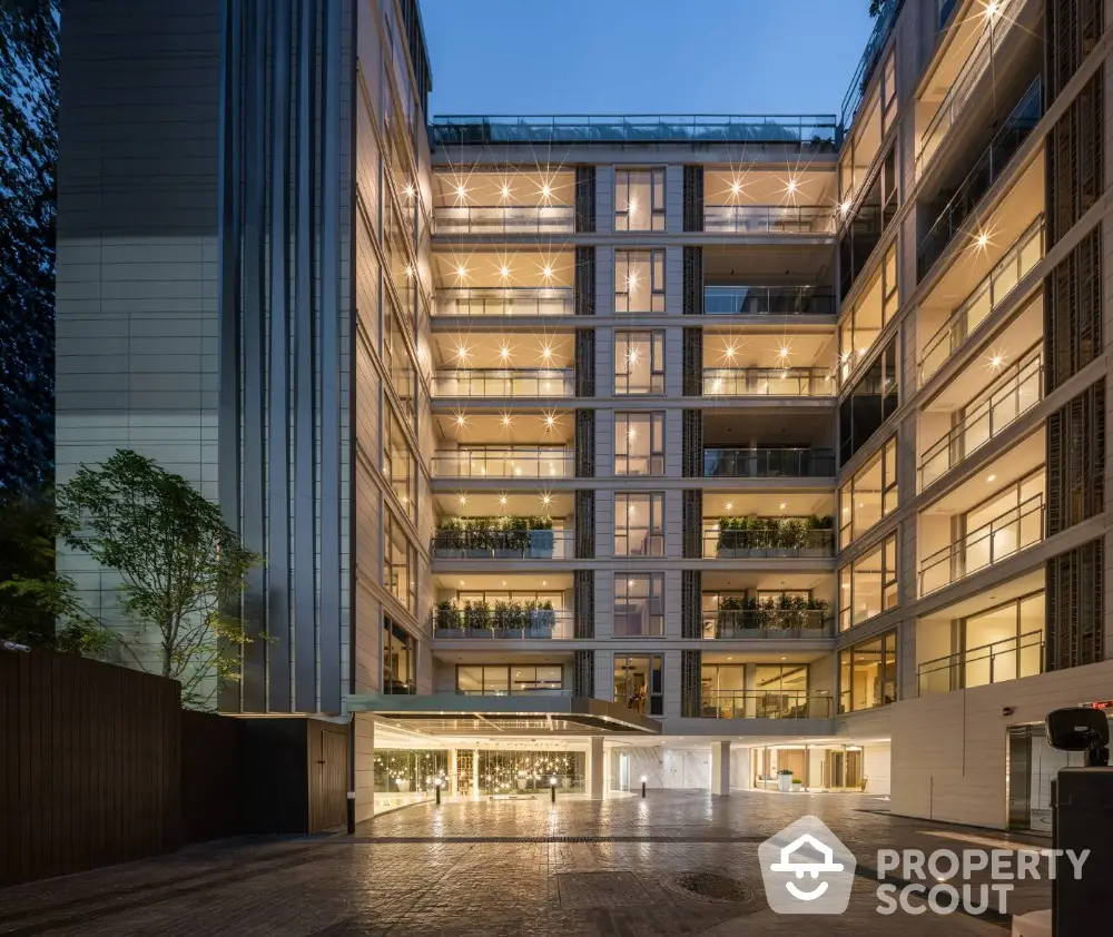 Modern luxury apartment building exterior with illuminated balconies and sleek design.