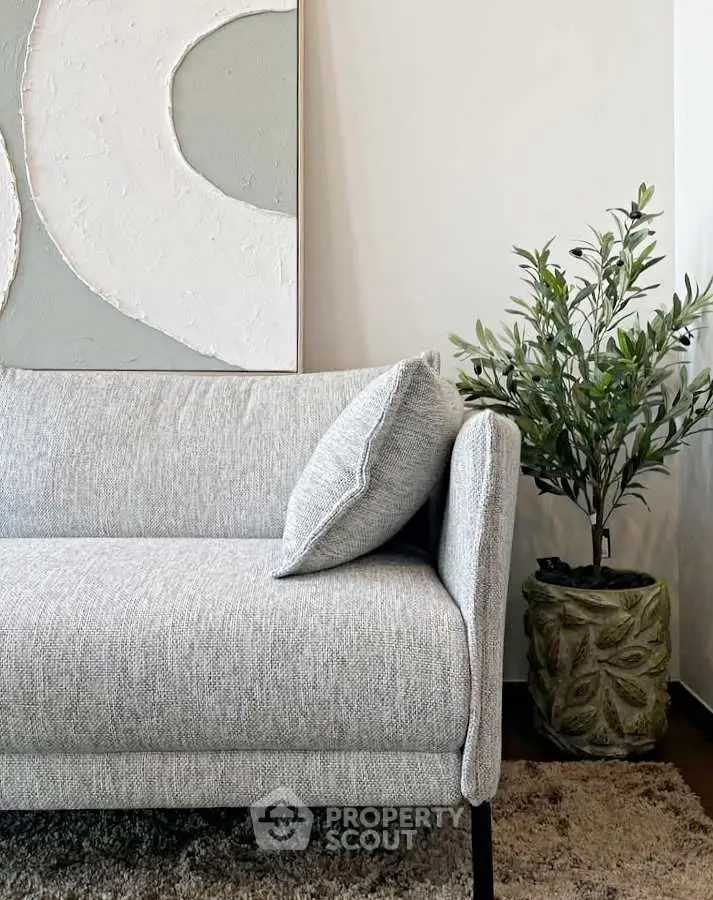 Stylish modern living room with elegant gray sofa and artistic wall decor