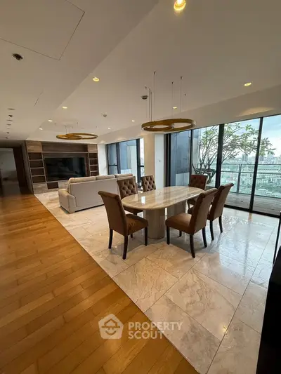 Luxurious open-plan living and dining area with elegant furnishings and a stunning city view from the balcony.
