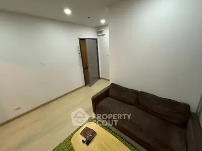 Cozy living room with brown sofa and wooden flooring, perfect for relaxation.