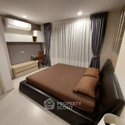 Spacious modern bedroom with elegant furnishings and ample natural light.
