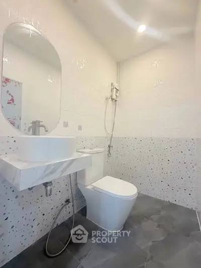 Modern bathroom with sleek design and elegant fixtures, featuring a stylish sink and contemporary toilet.