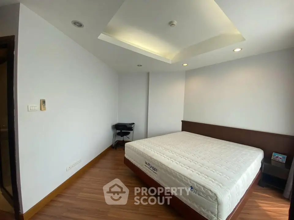 Spacious bedroom with modern design and wooden flooring in a stylish apartment.