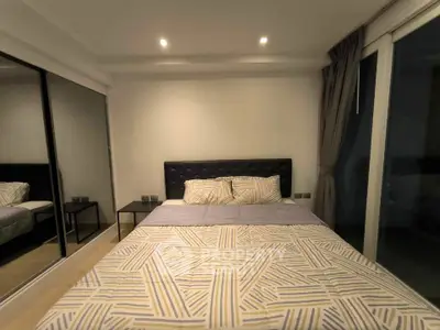 Modern bedroom with mirrored closet and stylish bedding in a cozy apartment.