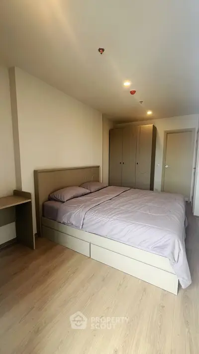 Modern bedroom with sleek wooden flooring and minimalist furniture design.