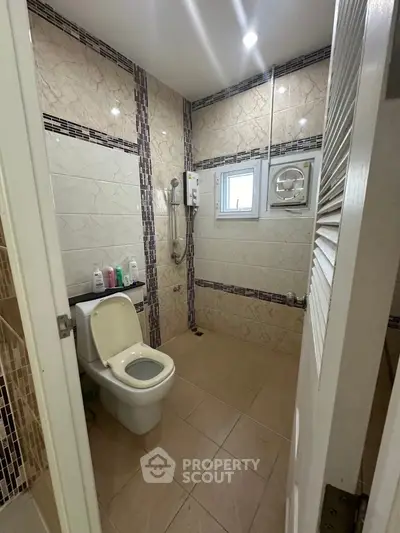 Modern bathroom with stylish tile design and essential fixtures in a contemporary home.