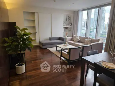 Spacious modern living room with large windows and elegant decor in urban apartment.